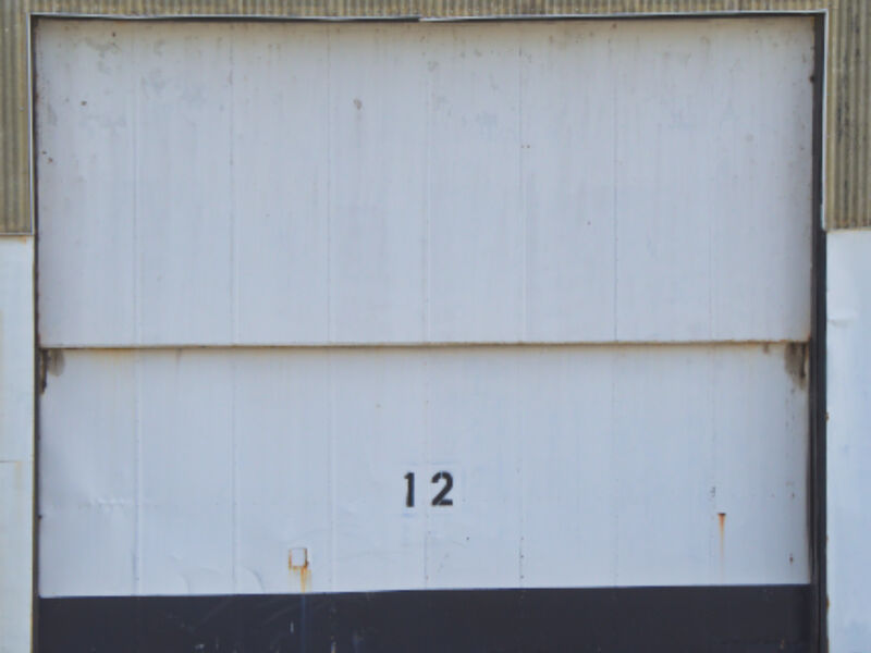 An industrial roll-up garage door on a workshop facade